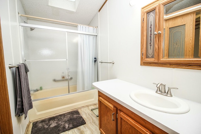 full bathroom featuring shower / bath combination with glass door, a textured ceiling, vanity, and wood finished floors