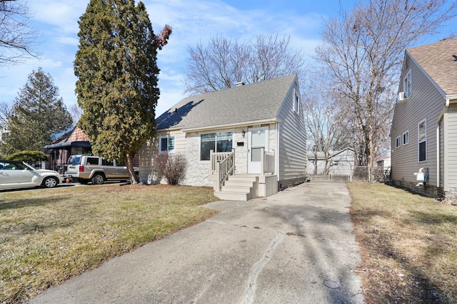 view of front facade featuring a front lawn and roof with shingles