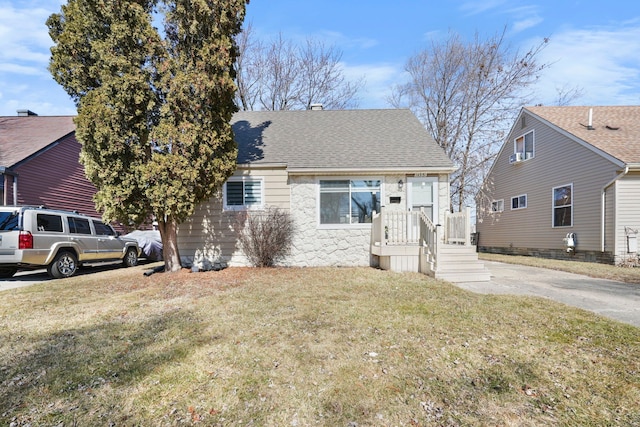 bungalow featuring roof with shingles and a front yard