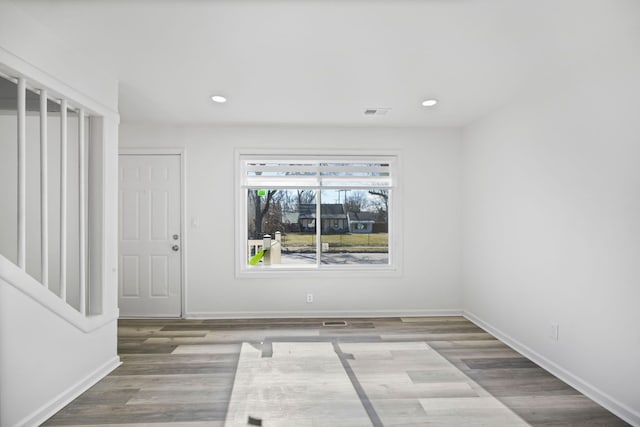 spare room featuring recessed lighting, wood finished floors, and baseboards