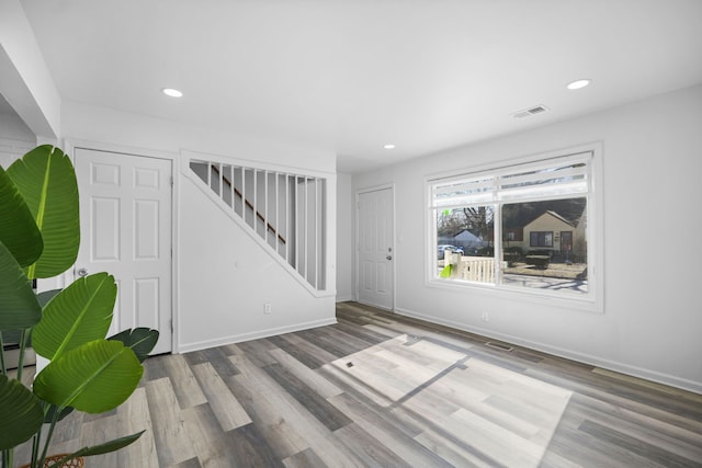 interior space featuring recessed lighting, visible vents, stairway, and wood finished floors