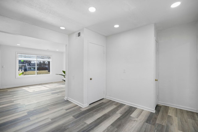 spare room with recessed lighting, wood finished floors, and baseboards