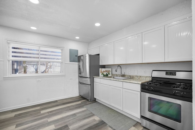 kitchen with light wood-style flooring, recessed lighting, stainless steel appliances, a sink, and white cabinetry