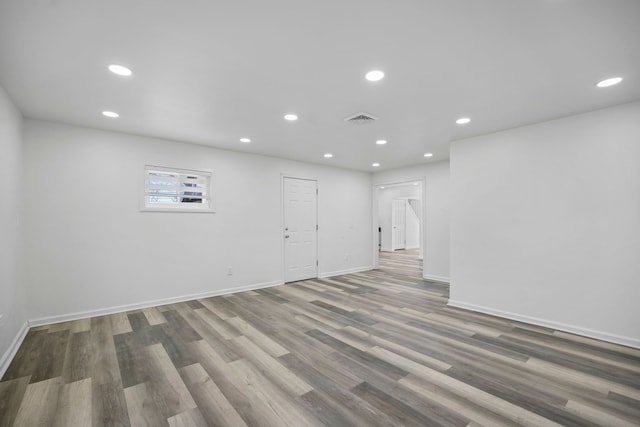 below grade area with baseboards, visible vents, wood finished floors, and recessed lighting