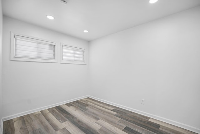 spare room with recessed lighting, baseboards, and wood finished floors