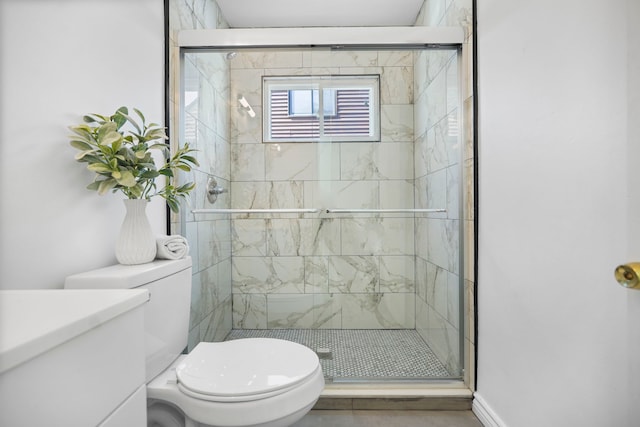 bathroom featuring toilet and a stall shower