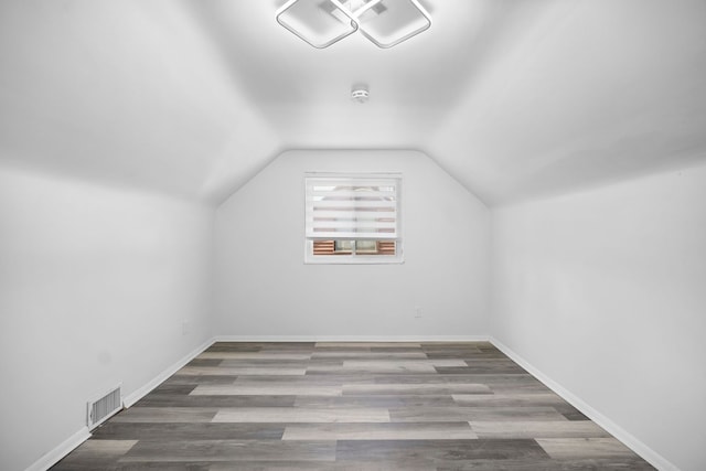 bonus room featuring vaulted ceiling, wood finished floors, visible vents, and baseboards