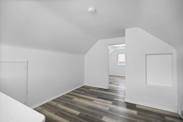 additional living space with lofted ceiling, baseboards, and wood finished floors