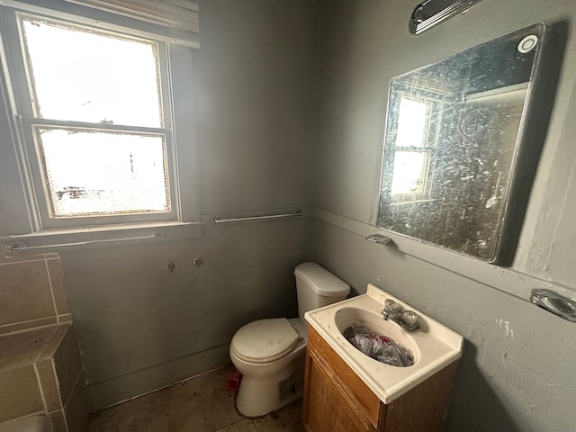 bathroom featuring a healthy amount of sunlight, toilet, and vanity