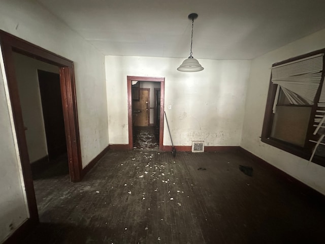 unfurnished dining area featuring dark wood-style floors and visible vents