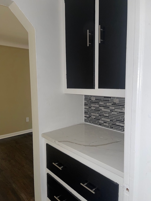 details featuring baseboards, decorative backsplash, and wood finished floors