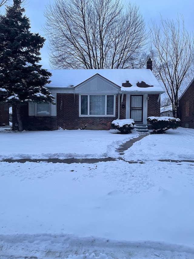 view of front of property featuring brick siding and a chimney