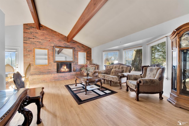 living area featuring light wood-type flooring, beam ceiling, a fireplace, and a wealth of natural light