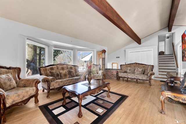 living room with lofted ceiling with beams, stairway, and light wood-style flooring