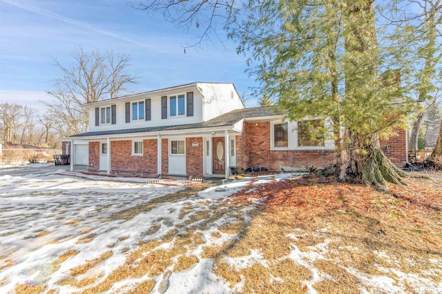 view of front of property with a garage, driveway, and brick siding