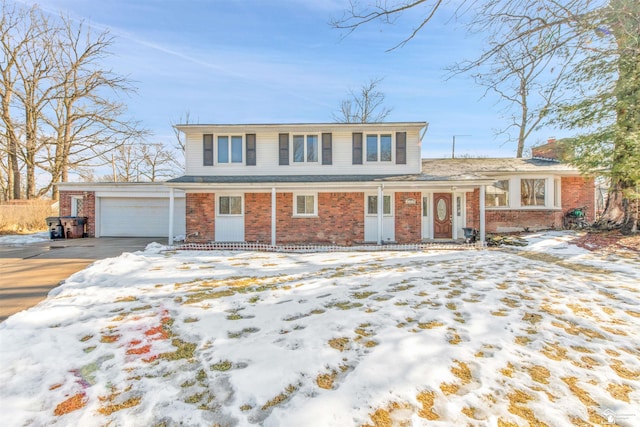 traditional-style home featuring brick siding, driveway, a chimney, and an attached garage