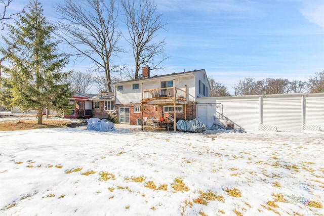 snow covered property with a chimney