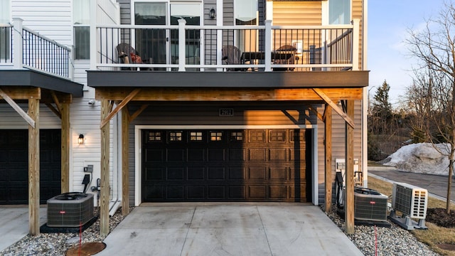 exterior space with central AC, concrete driveway, and an attached garage