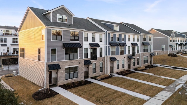 townhome / multi-family property featuring a shingled roof and a residential view