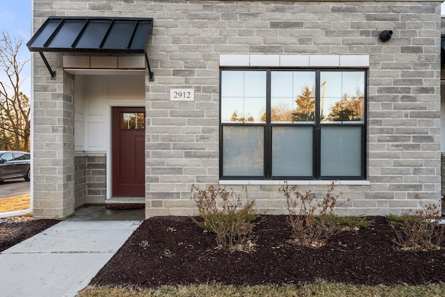 property entrance featuring brick siding