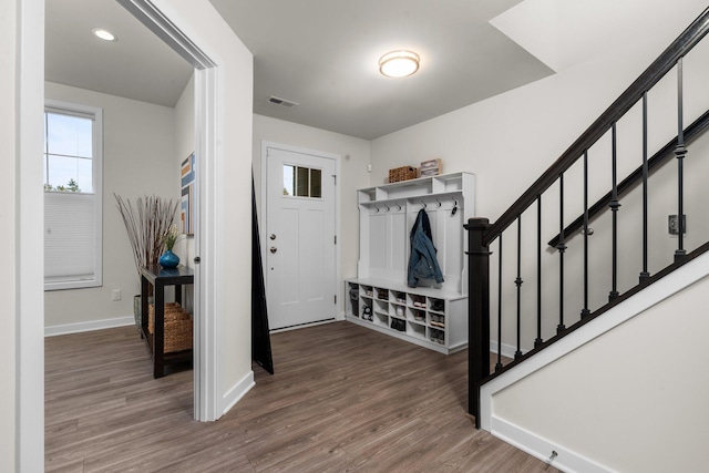 foyer entrance featuring stairway, wood finished floors, visible vents, and baseboards