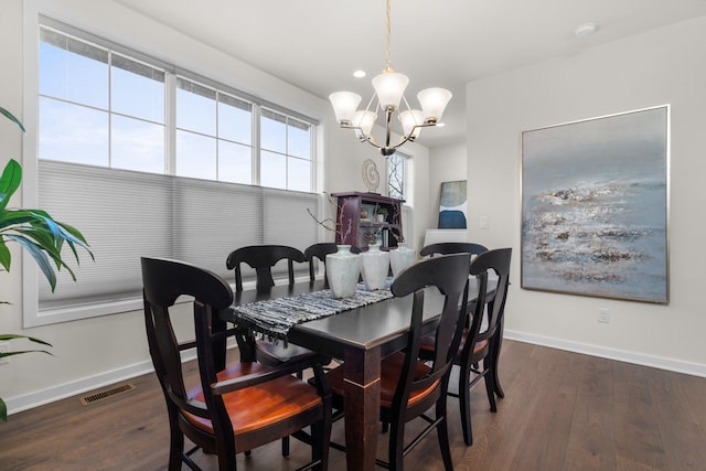 dining space with an inviting chandelier, baseboards, visible vents, and wood finished floors