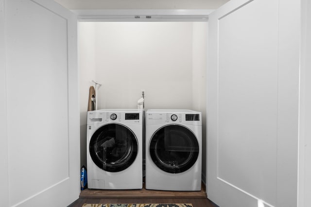 laundry room with laundry area, washer and clothes dryer, and wood finished floors