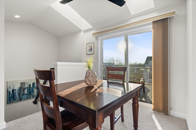 dining room featuring lofted ceiling with skylight, recessed lighting, light colored carpet, and baseboards