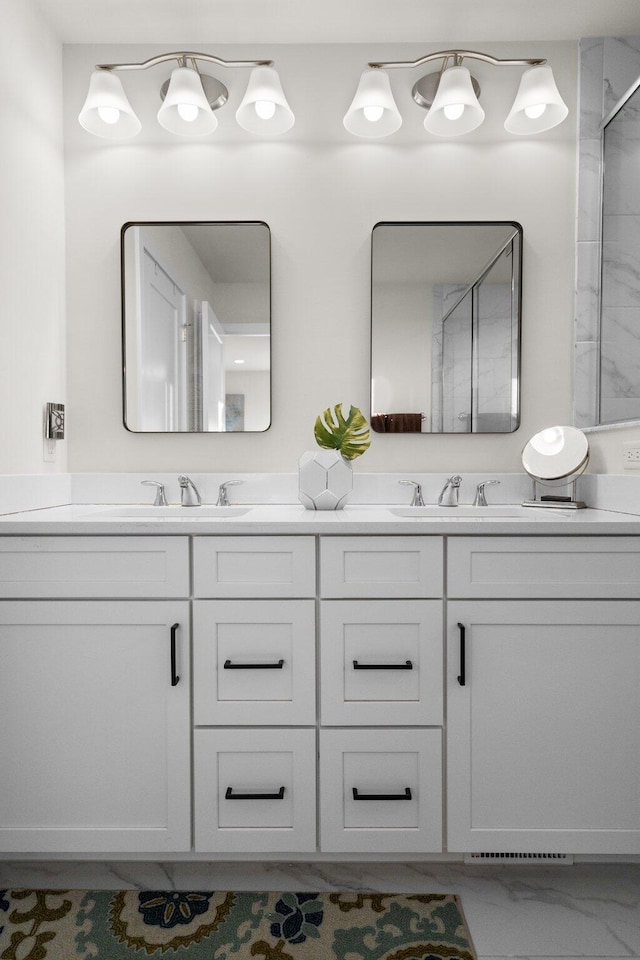 full bath with marble finish floor, a sink, and double vanity