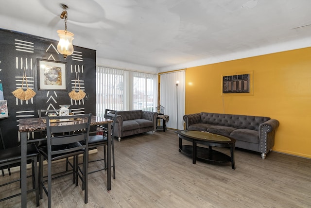 living room with baseboards, wood finished floors, and a wall mounted air conditioner