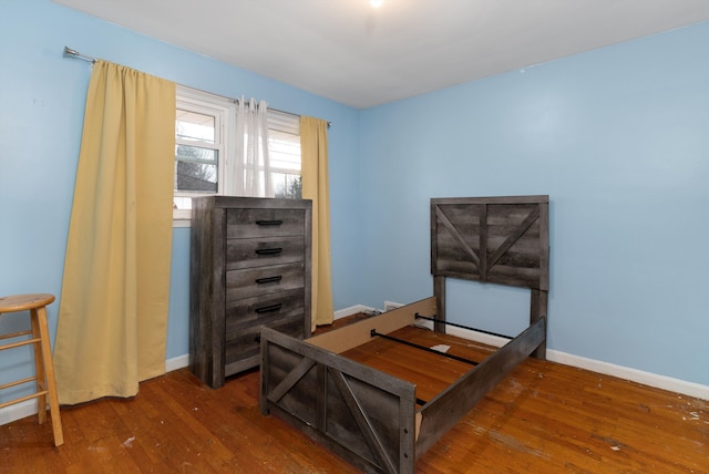 bedroom with baseboards and hardwood / wood-style flooring