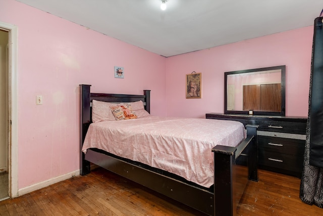 bedroom featuring baseboards and hardwood / wood-style flooring