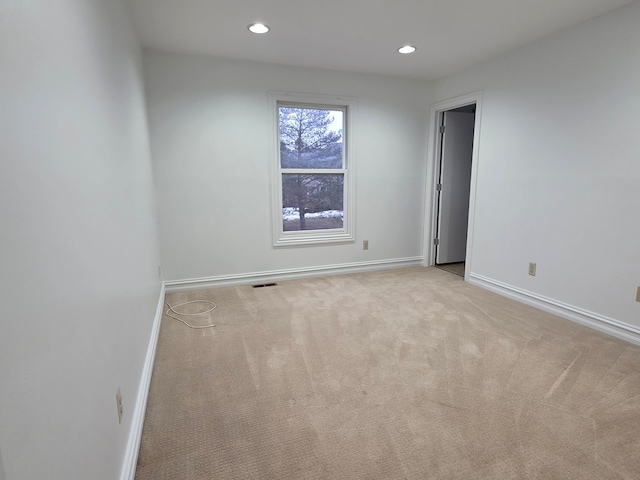 spare room with recessed lighting, light colored carpet, visible vents, and baseboards