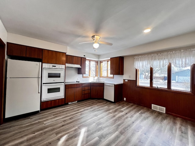 kitchen featuring white appliances, light wood finished floors, visible vents, light countertops, and a sink