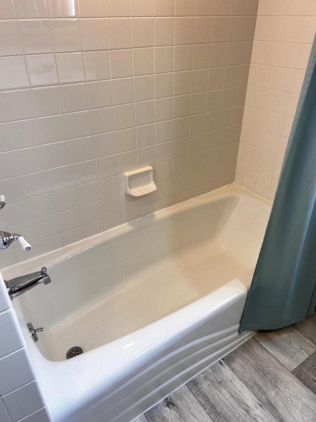 bathroom with shower / bath combination with curtain and wood finished floors