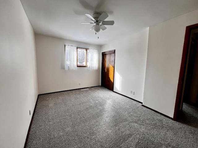 empty room with ceiling fan and baseboards