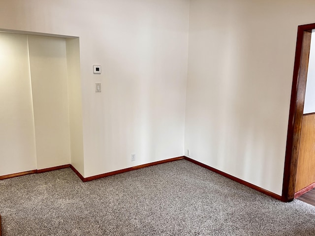 unfurnished room featuring carpet floors and baseboards