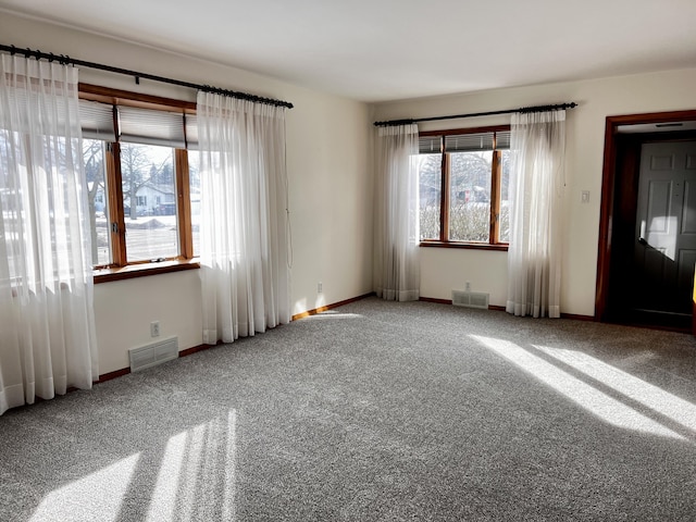 carpeted spare room with visible vents and baseboards