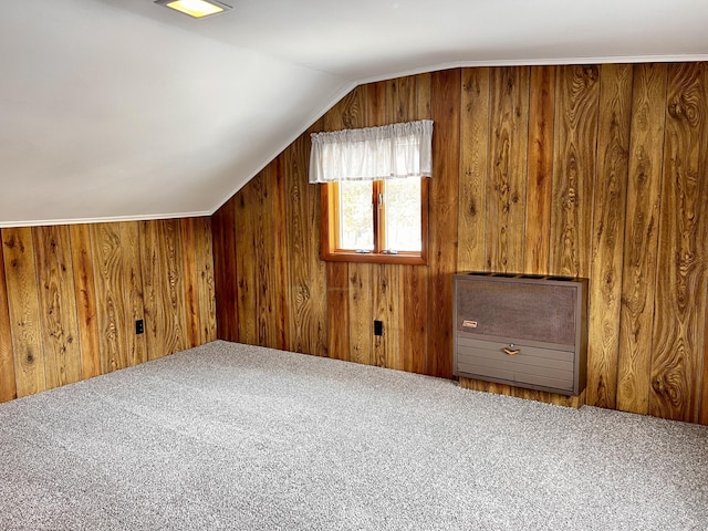 bonus room featuring lofted ceiling, carpet, and wooden walls