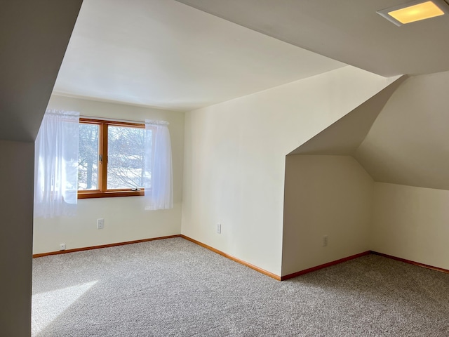 additional living space with vaulted ceiling, carpet flooring, and baseboards