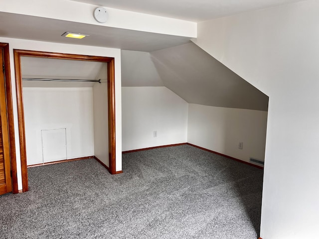 additional living space featuring baseboards, visible vents, vaulted ceiling, and carpet flooring