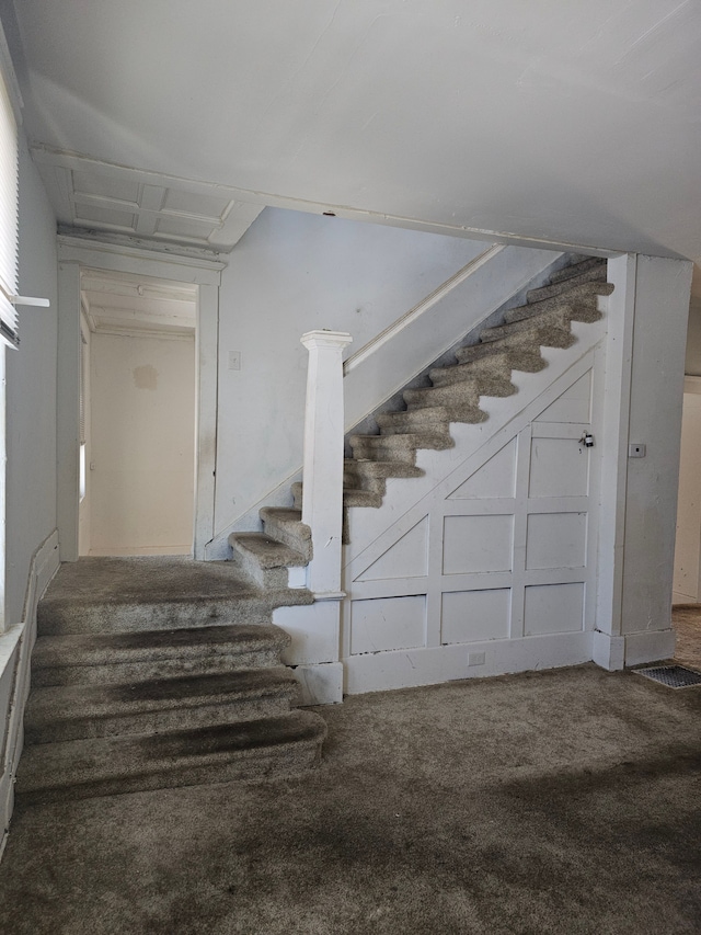 staircase featuring carpet