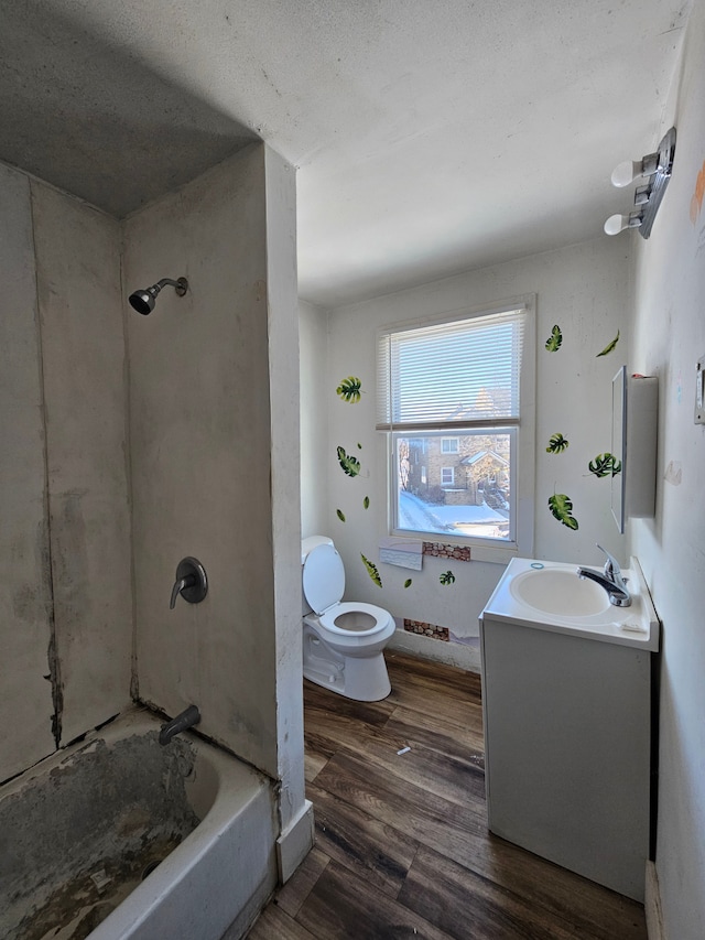 bathroom with toilet, shower / bathing tub combination, wood finished floors, and vanity