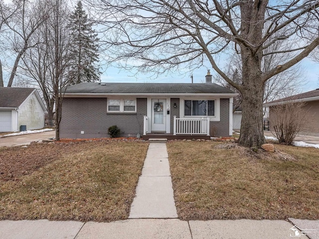 view of front of property featuring brick siding, a chimney, and a front lawn