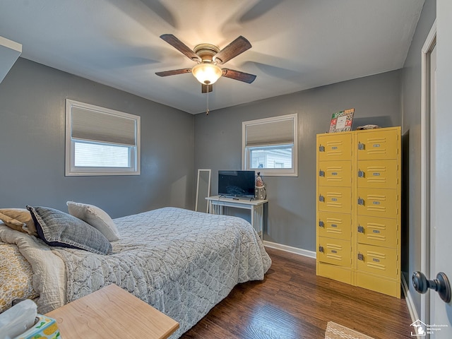 bedroom with ceiling fan, multiple windows, baseboards, and dark wood-type flooring