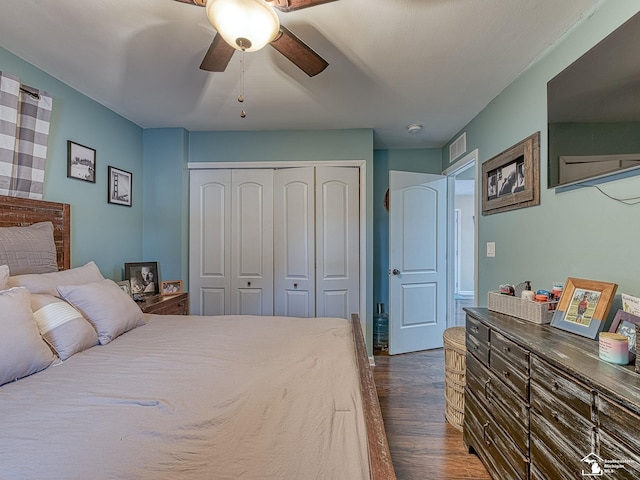 bedroom featuring dark wood-style floors, a closet, visible vents, and a ceiling fan