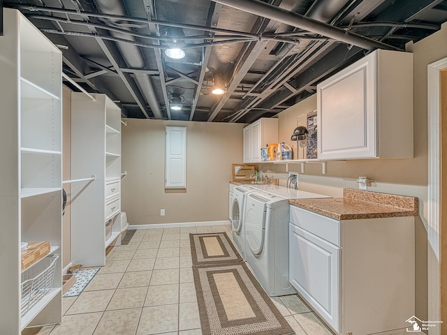 laundry area featuring washing machine and dryer, cabinet space, and light tile patterned flooring