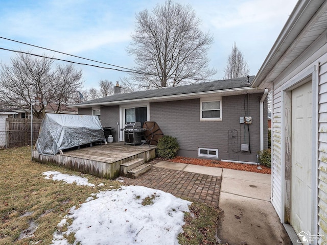 back of house with a patio, a chimney, fence, a wooden deck, and brick siding