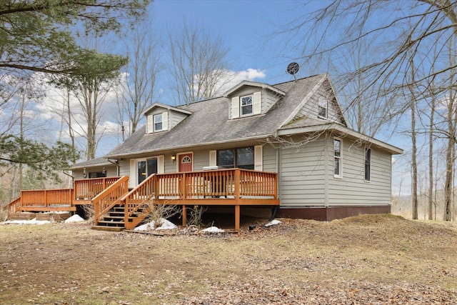 view of front facade featuring roof with shingles and a wooden deck