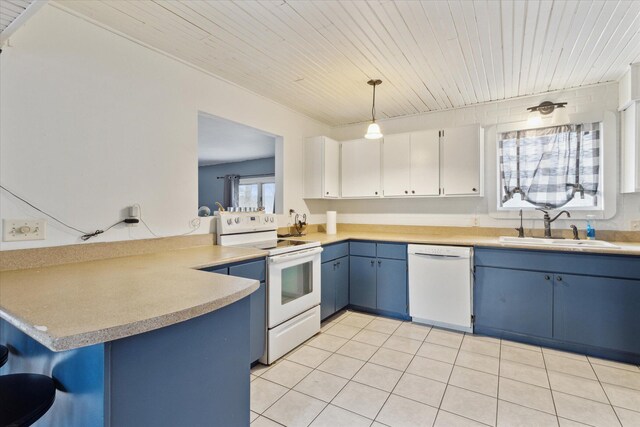 kitchen featuring white appliances, light countertops, a sink, and blue cabinetry